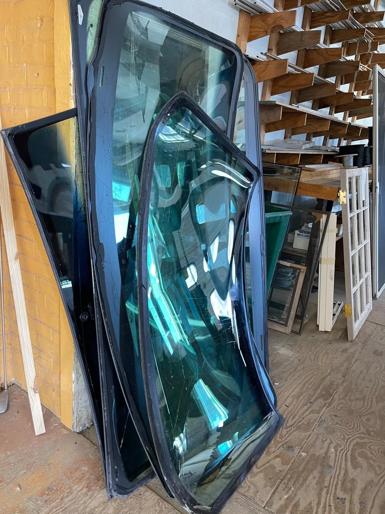 Tinted auto glass stored on the shop racks, ready to be fitted