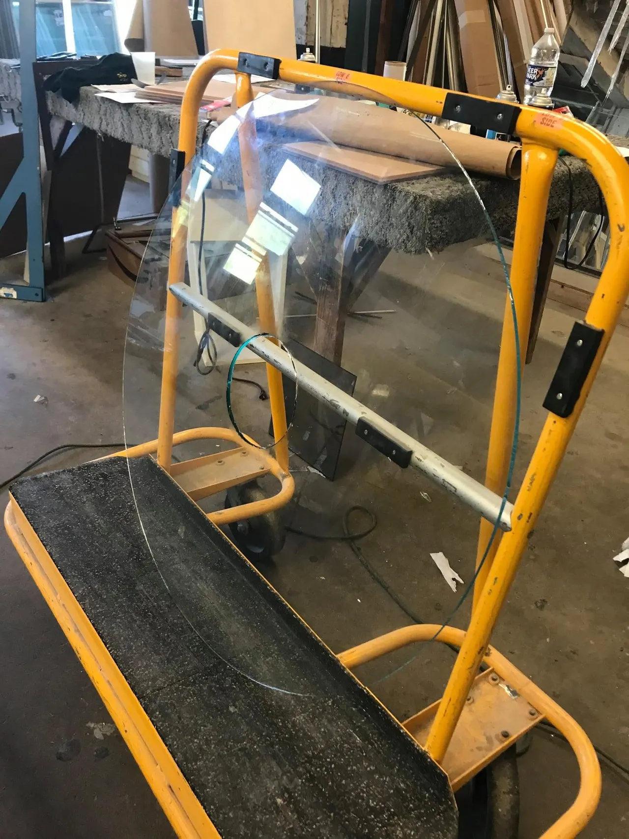 Curved laminated glass standing in a shop cart in the fabrication area