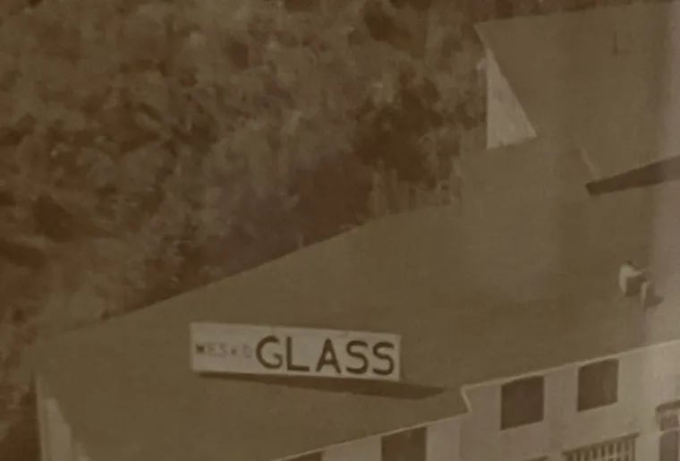 A black-and-white photograph of the original 1960s Mesko Glass rooftop sign, from the family archive.