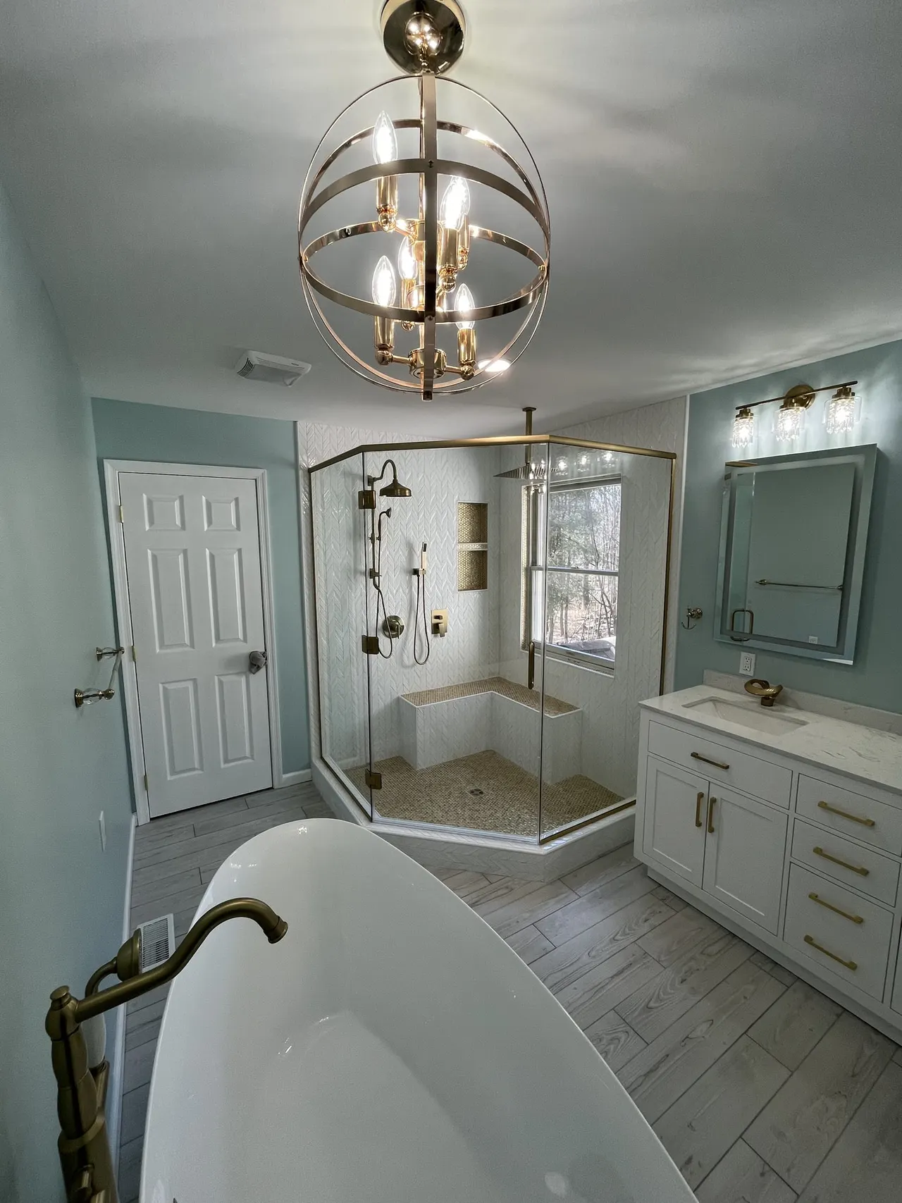 Neo-angle glass shower enclosure with brass hardware, real Mesko Glass installation.